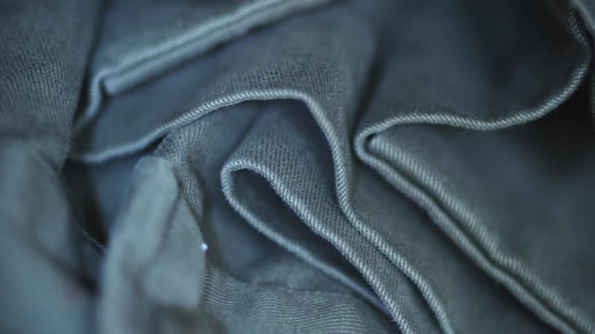 Fabric of blue denim is folded and in a pile