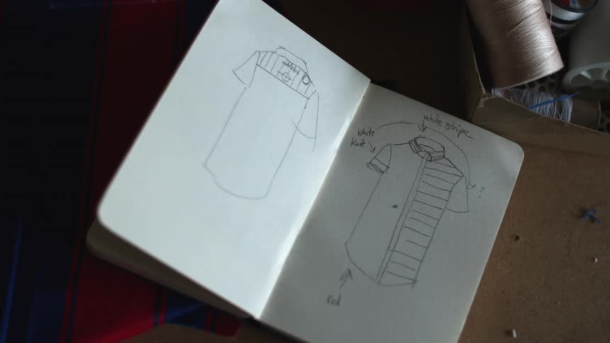 Clothing patterns drawn on a notebook over a table