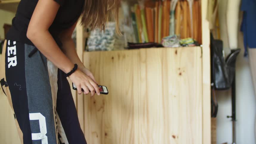 Woman using a white iphone to snap a picture of a red fabric on the floor