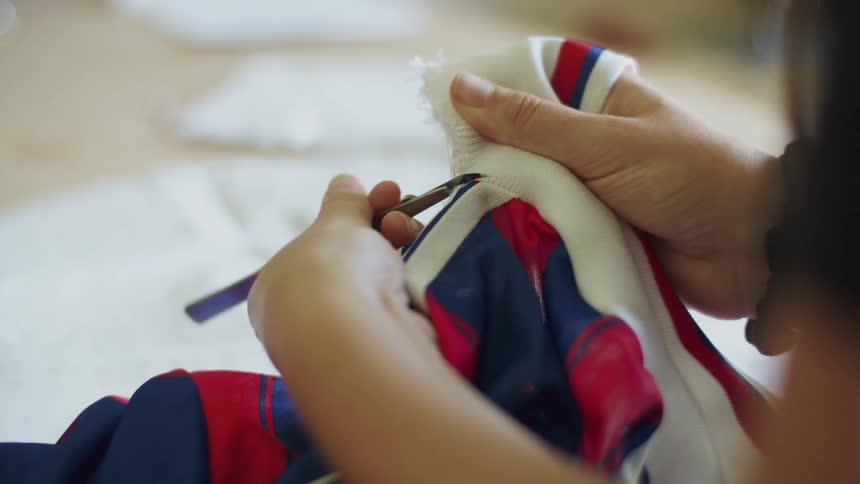 A woman is sewing a shirt indoors
