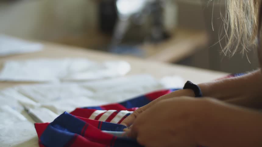 Woman using a seam ripper on a piece of clothing