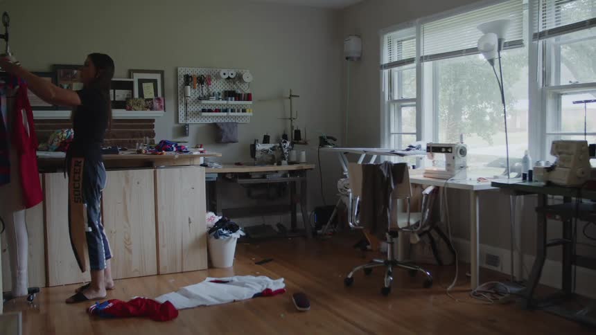 Woman tailoring clothes over a mannequin in a home workshop
