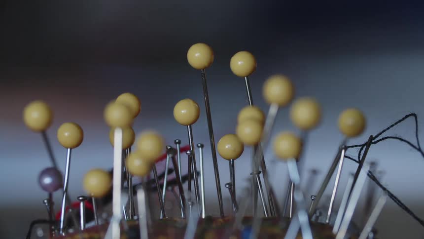 Sewing needles and sewing pins with yellow balls on top