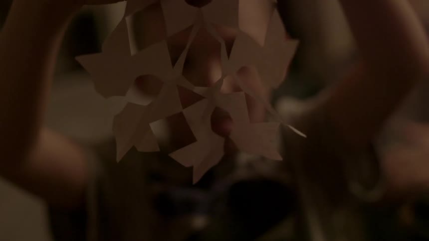 Person admiring their origami work that they hold in front of them