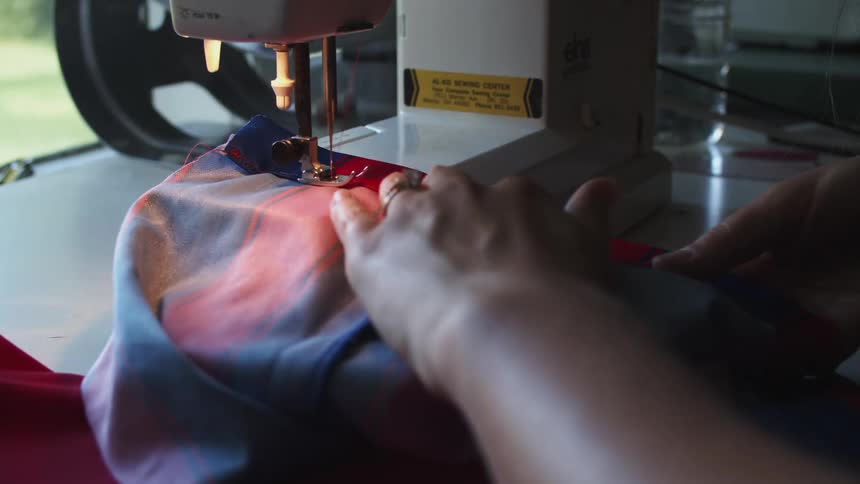 Woman sewing clothes on a sewing machine at home