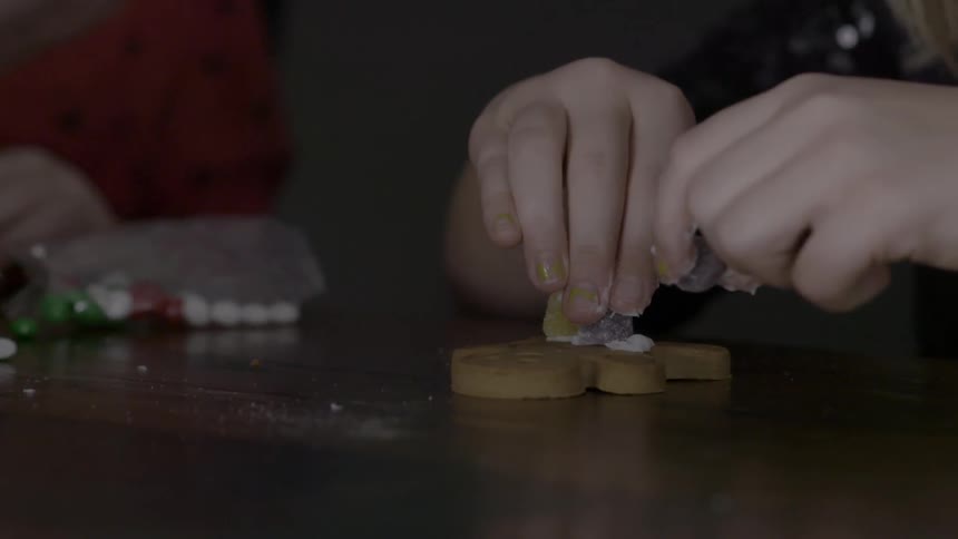 Person decorating a gingerbread man
