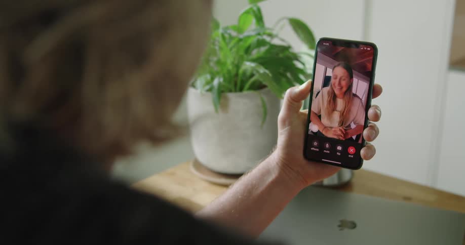 A woman smiles as she is seen on the other end of a video call on a smart phone