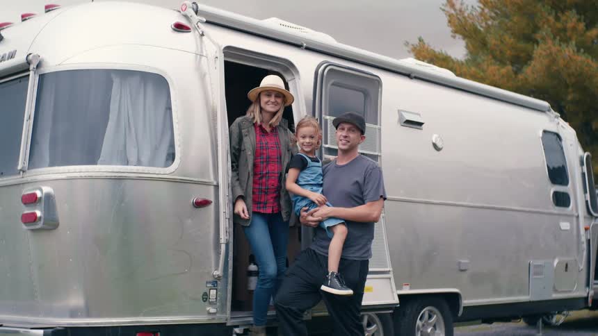 A family posing in front of their recreational vehicle