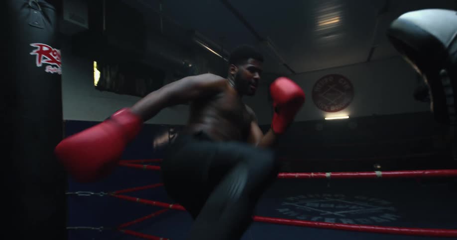 Two boxers boxing in a boxing ring in a room