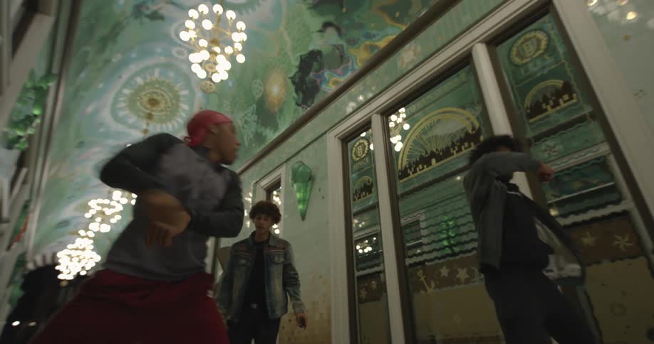 Four teenagers dancing in a hallway in a building
