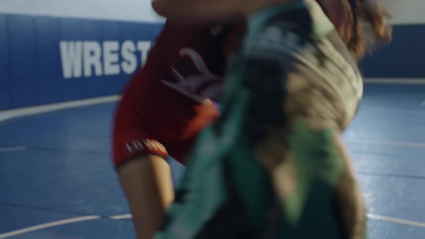 Two girls practicing wrestling in a gymnasium
