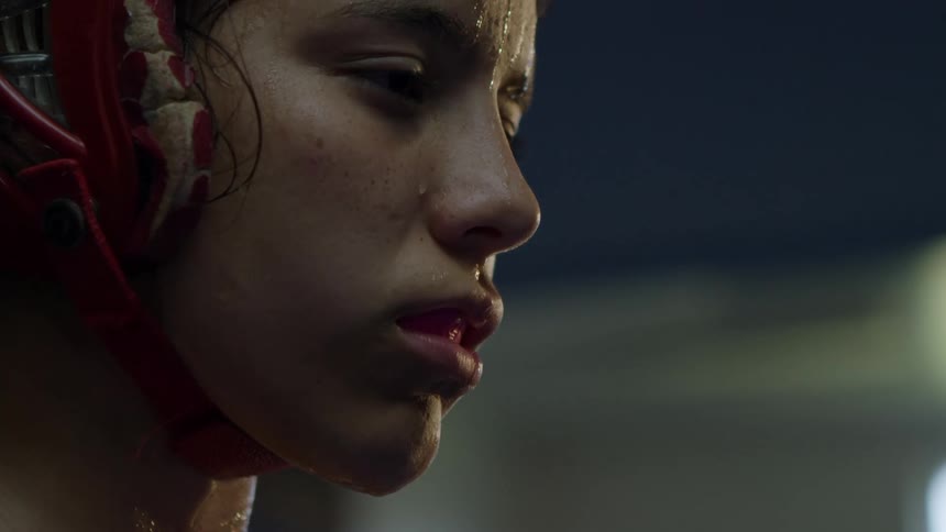 Sweat drips down the chin of a female boxer