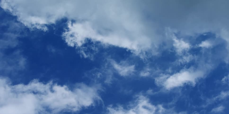 Clouds float in the blue sky