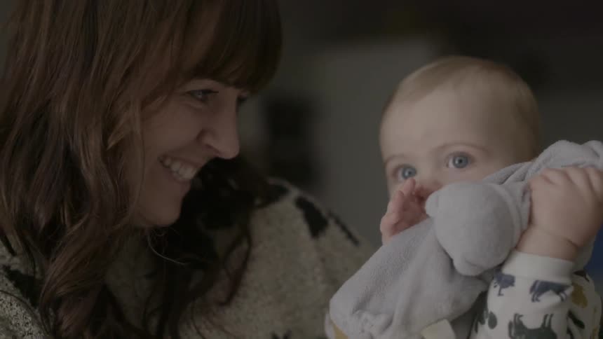 A woman smiles at a baby