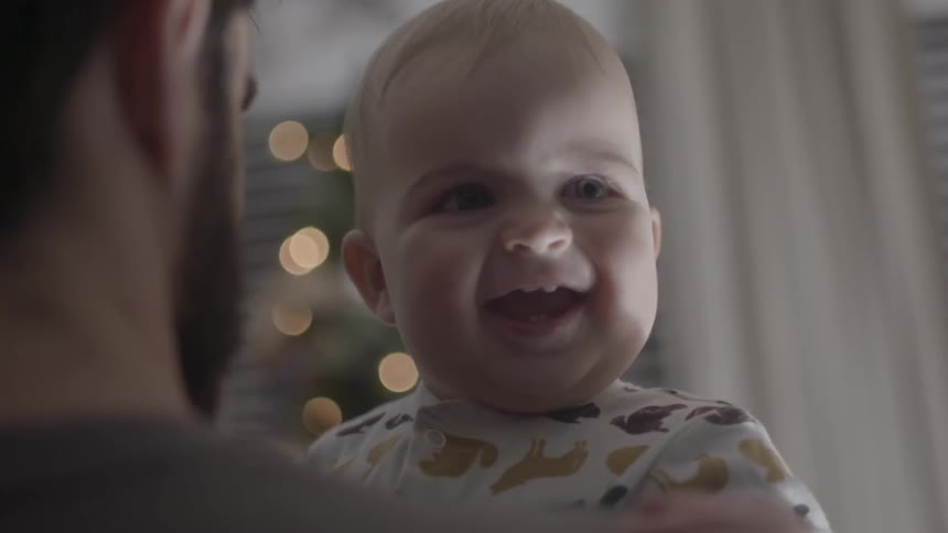 Man holding a baby with a huge smile on its face