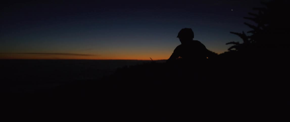Silhouette of a cyclist riding a bicycle at sunset