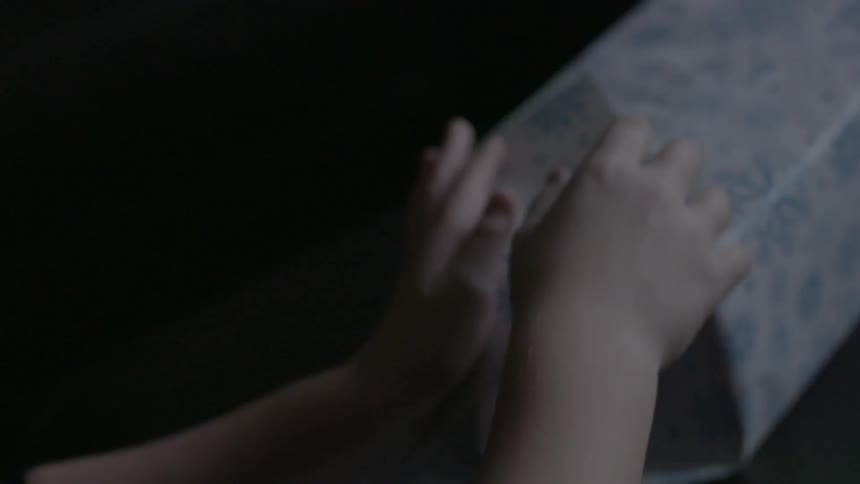 A little girl wrapping a christmas present