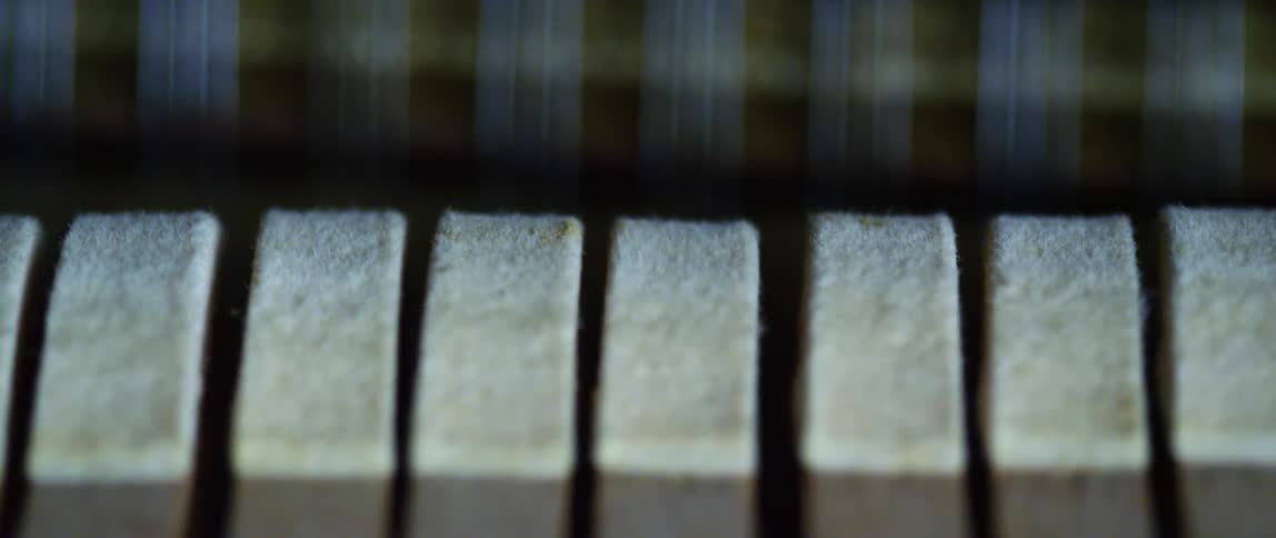 Beige piano hammers move up and down