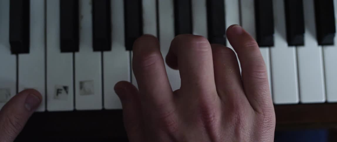 Close up of fingers playing on a piano