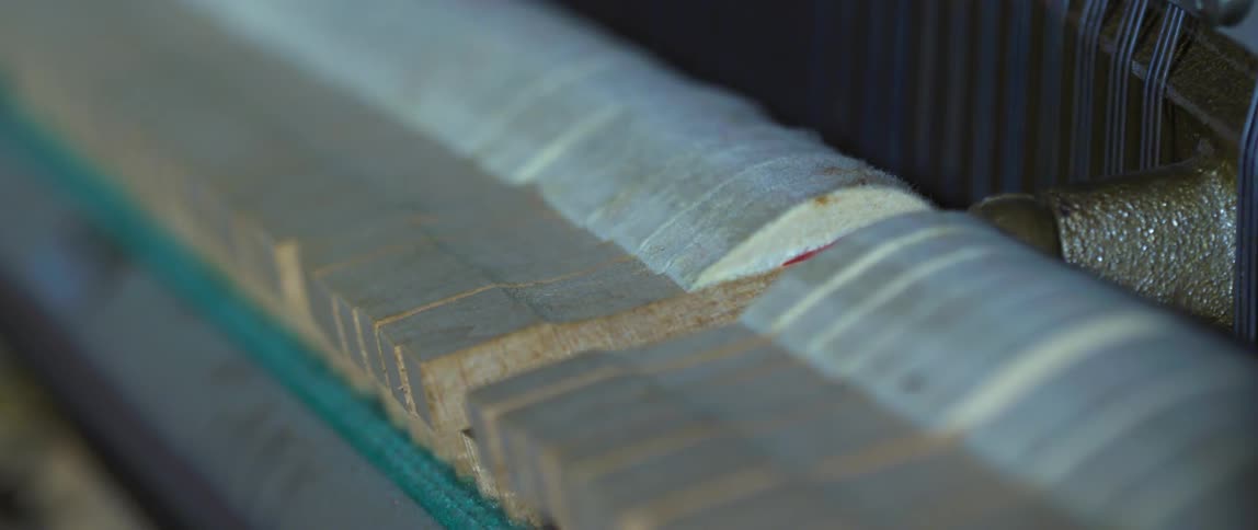 Close up of piano hammers moving over the strings