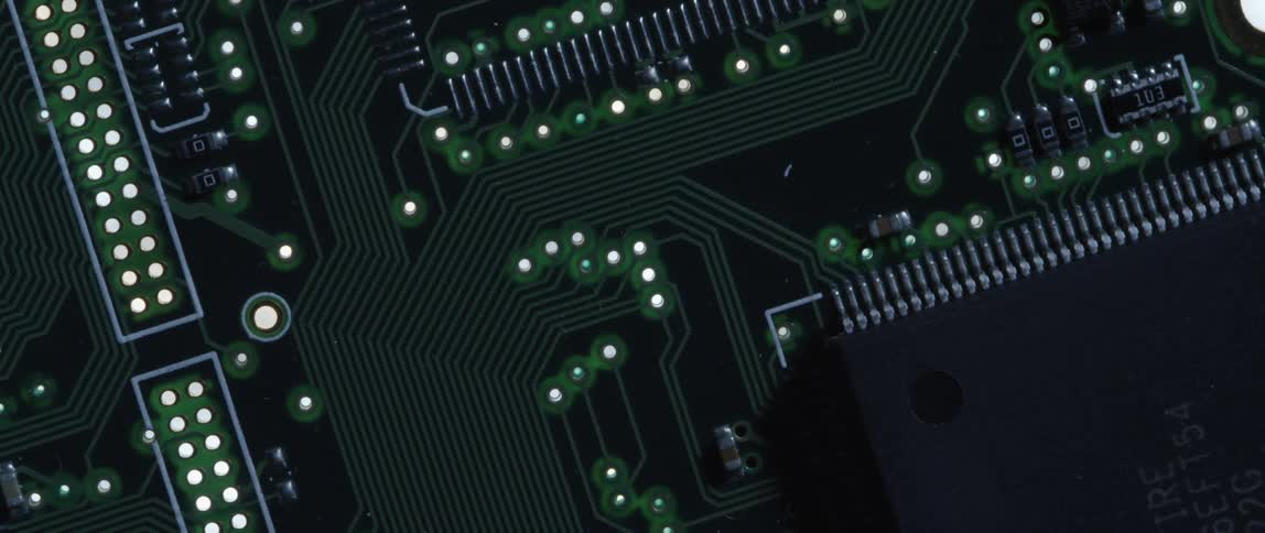A close up of a black circuit board with lights and tiny metal pieces