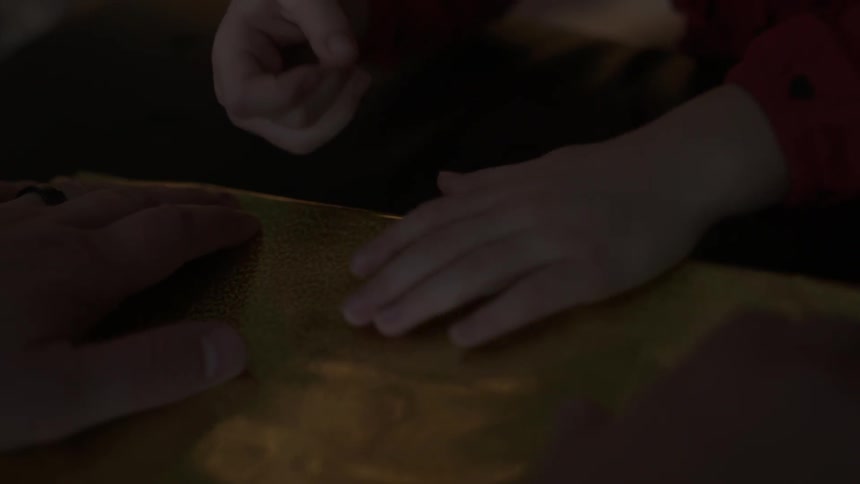 A child tapes the wrapping paper on a present