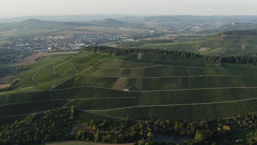 An aerial view of agricultural fields on a rural hill in the daytime