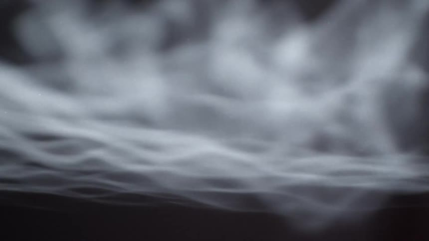 Close up black and white footage of flowing white smoke