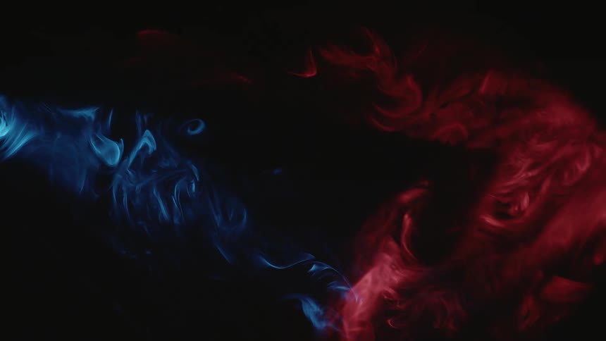 Red and blue smoke twirling in slow motion against a black background