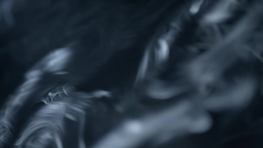 White smoke swirling through darkness