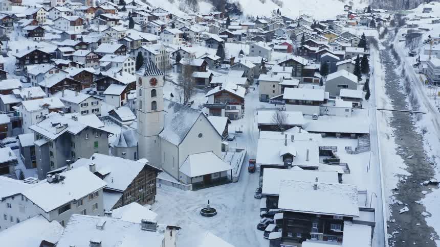 Vehicle driving on the snow covered narrow streets of a town at winter