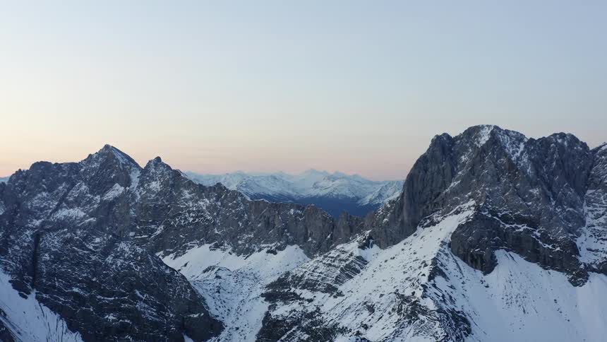 Aerial view of snow covered mountains is displayed