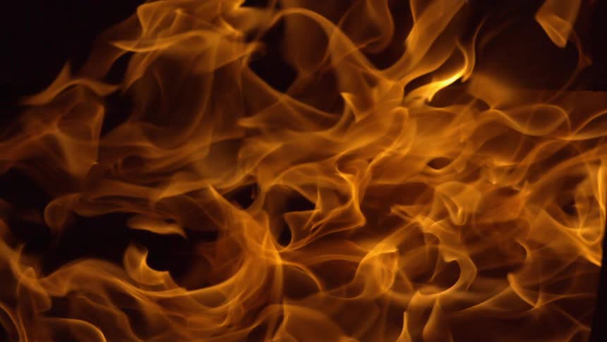 A wave of yellow flame flowing over a black background