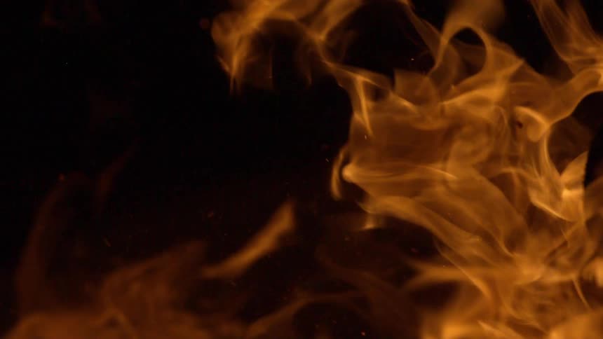 Close up of yellow flames on a fire at night