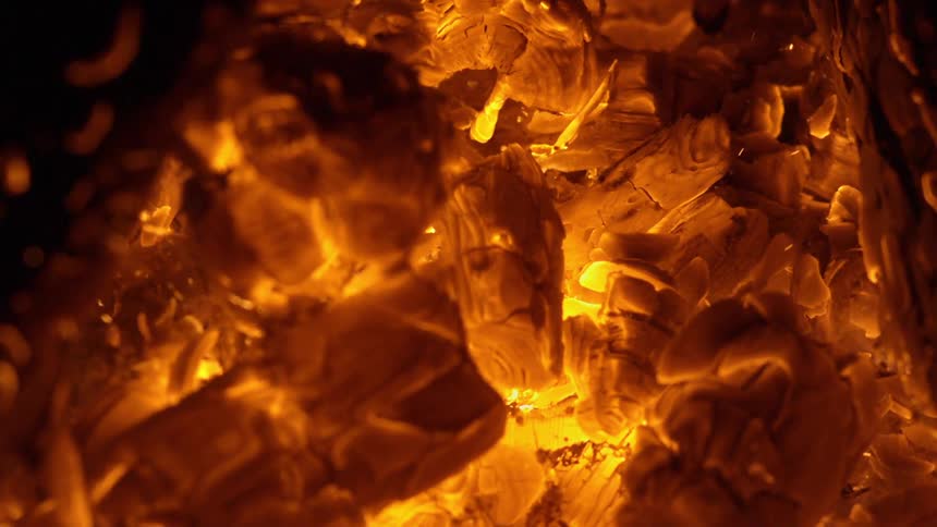 Red and orange embers flying off of burning paper and wood