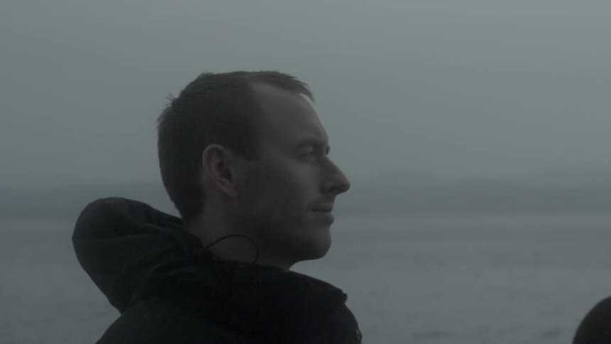 A man is standing outside on a foggy day
