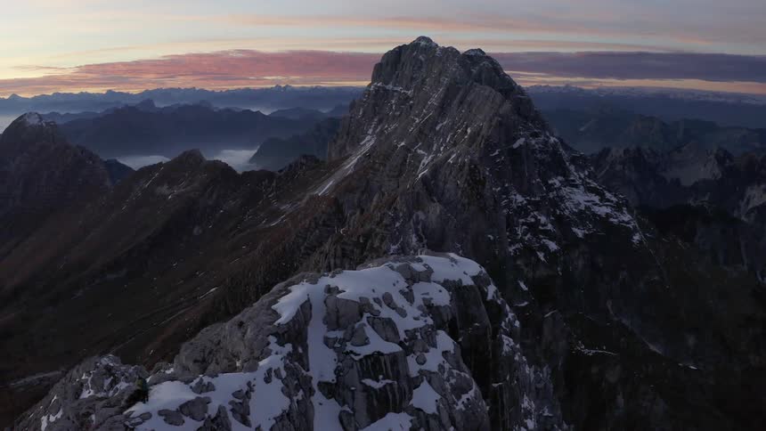 An aerial view of snowy mountain peaks in the wilderness at sunrise