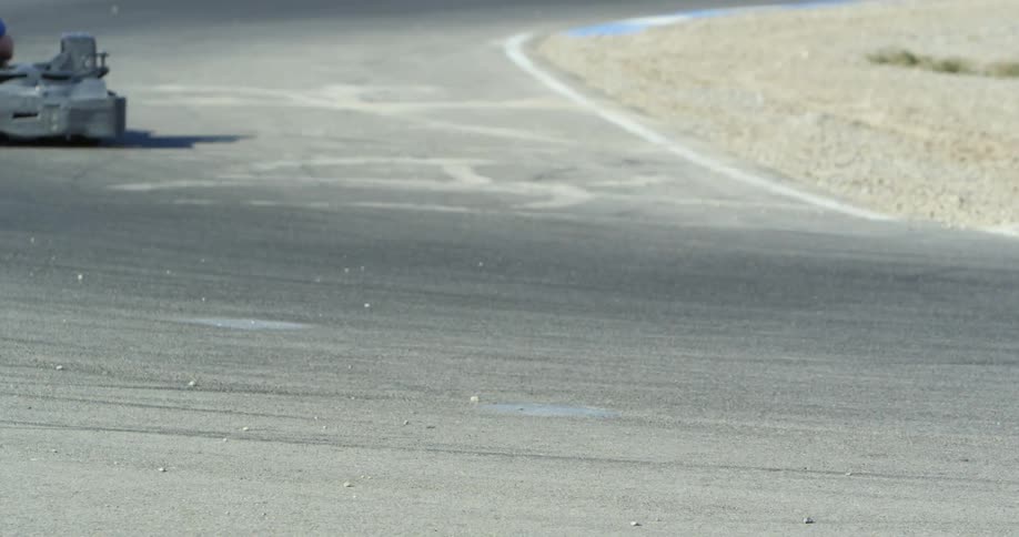 Competing go karts speeding over the curve on a race track