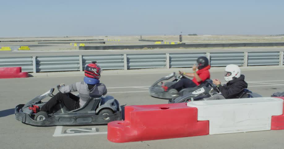 People driving go carts on a race track start the competition