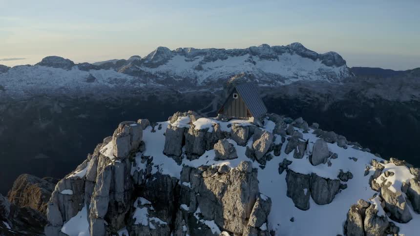 Aerial view of snow covered mountains at dusk is displayed