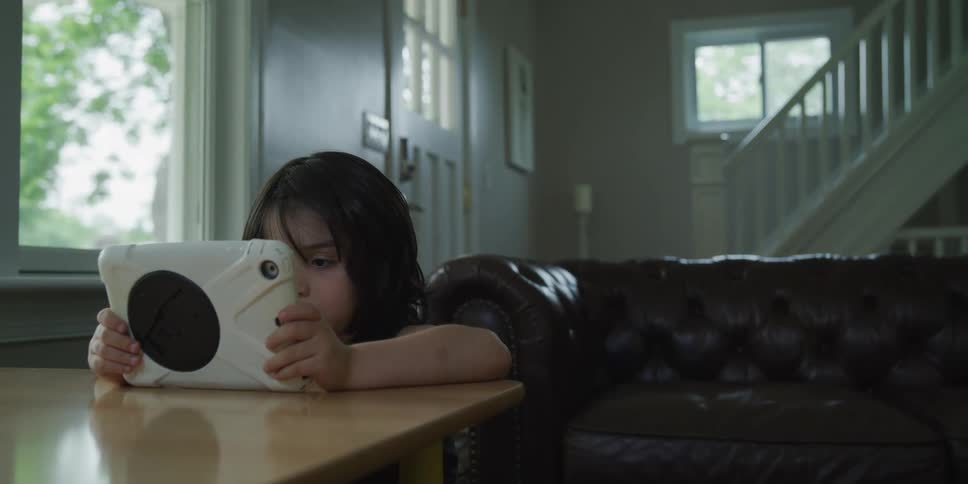 A young boy at home looks at an electronic toy