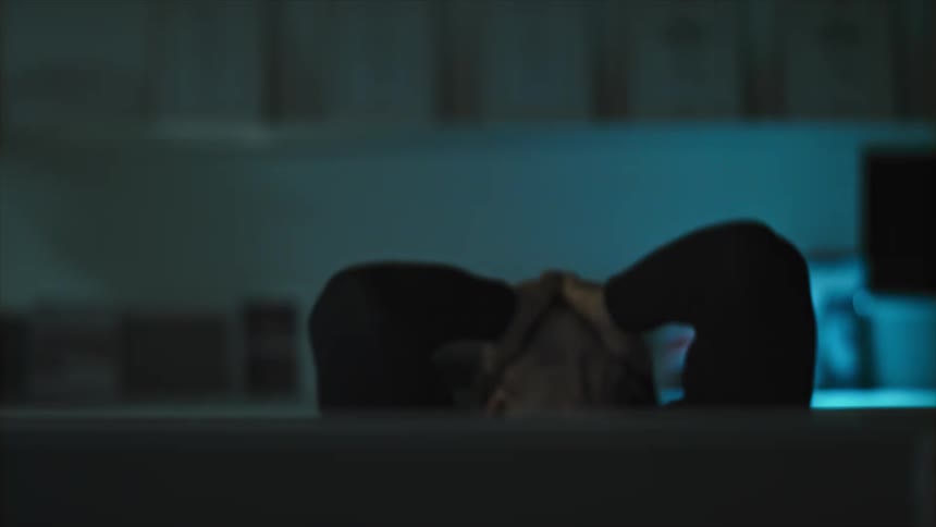 Man sitting in front of a computer tilts his head back in frustration