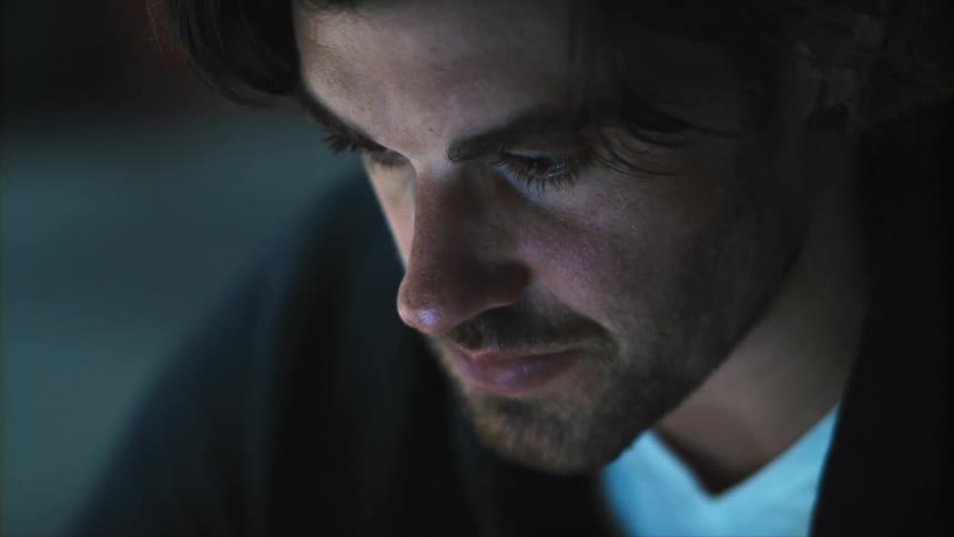 A man is sitting in a room indoors