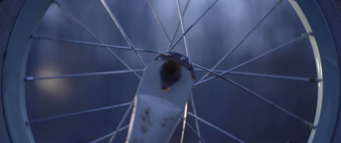 A wheel is spinning on a bike outdoors