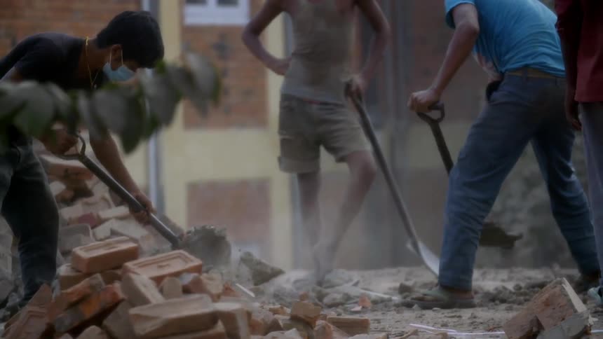Men moving bricks with shovels