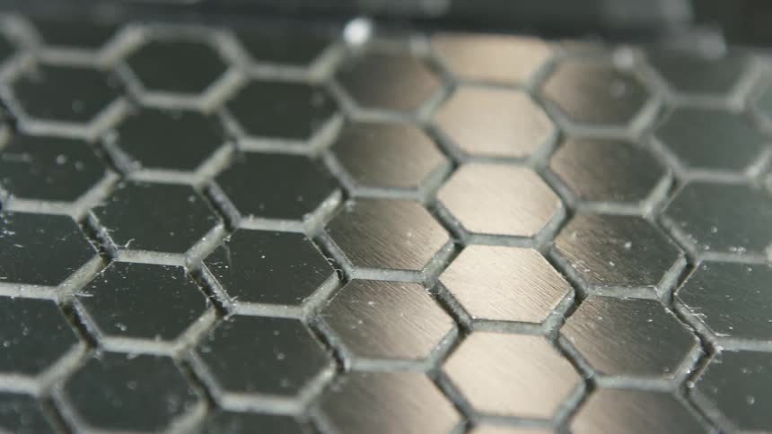 Slat of silver metal with hexagon shapes across the surface