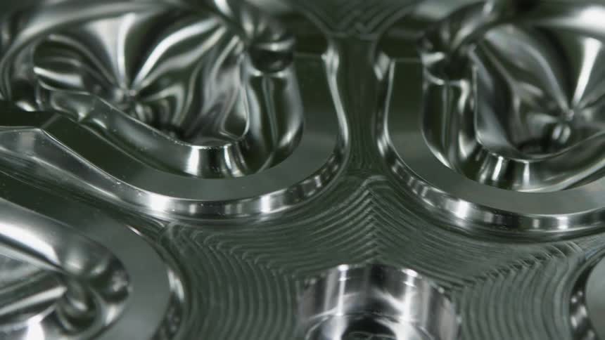 A metal component that was carved with high precision reflects light from many of its surfaces