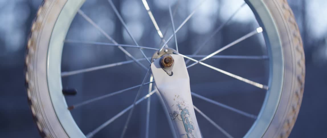 Upside down bicycle wheel spinning in the air outdoors