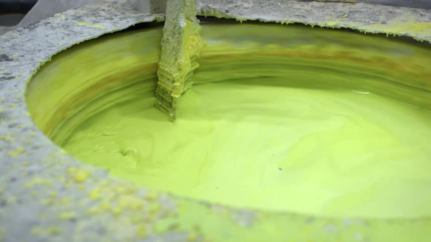 A container with green paint spins while being mixed