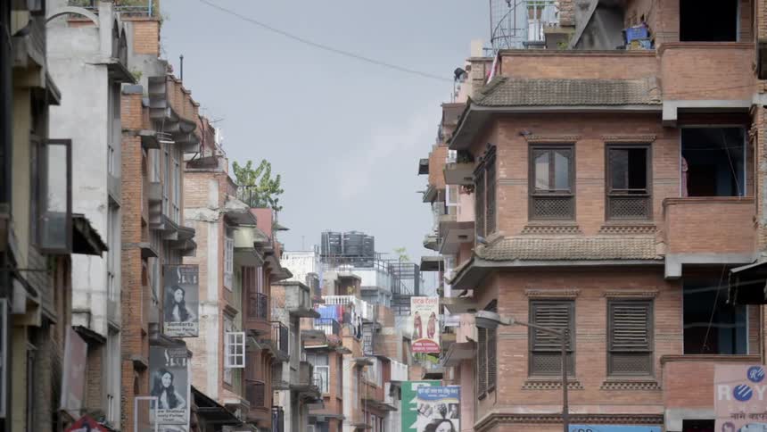 Birds flying between buildings on a city street
